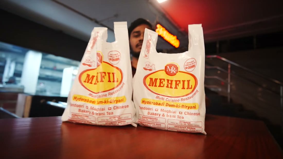 Two Mehfil takeaway bags packed and waiting on a counter